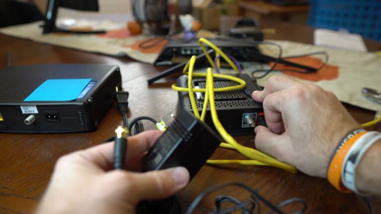 The Image Shows a Person Connecting Cables to A Modem and A Router, with Yellow Ethernet Cables Plugged Into the Devices and The Person Holding a Power Adapter